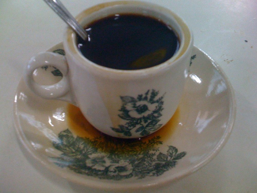 A cup of kopi o on a saucer.