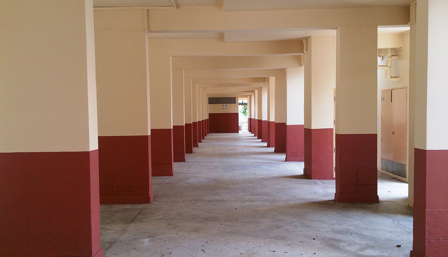 Tables and chairs in a void deck under an HDB block.